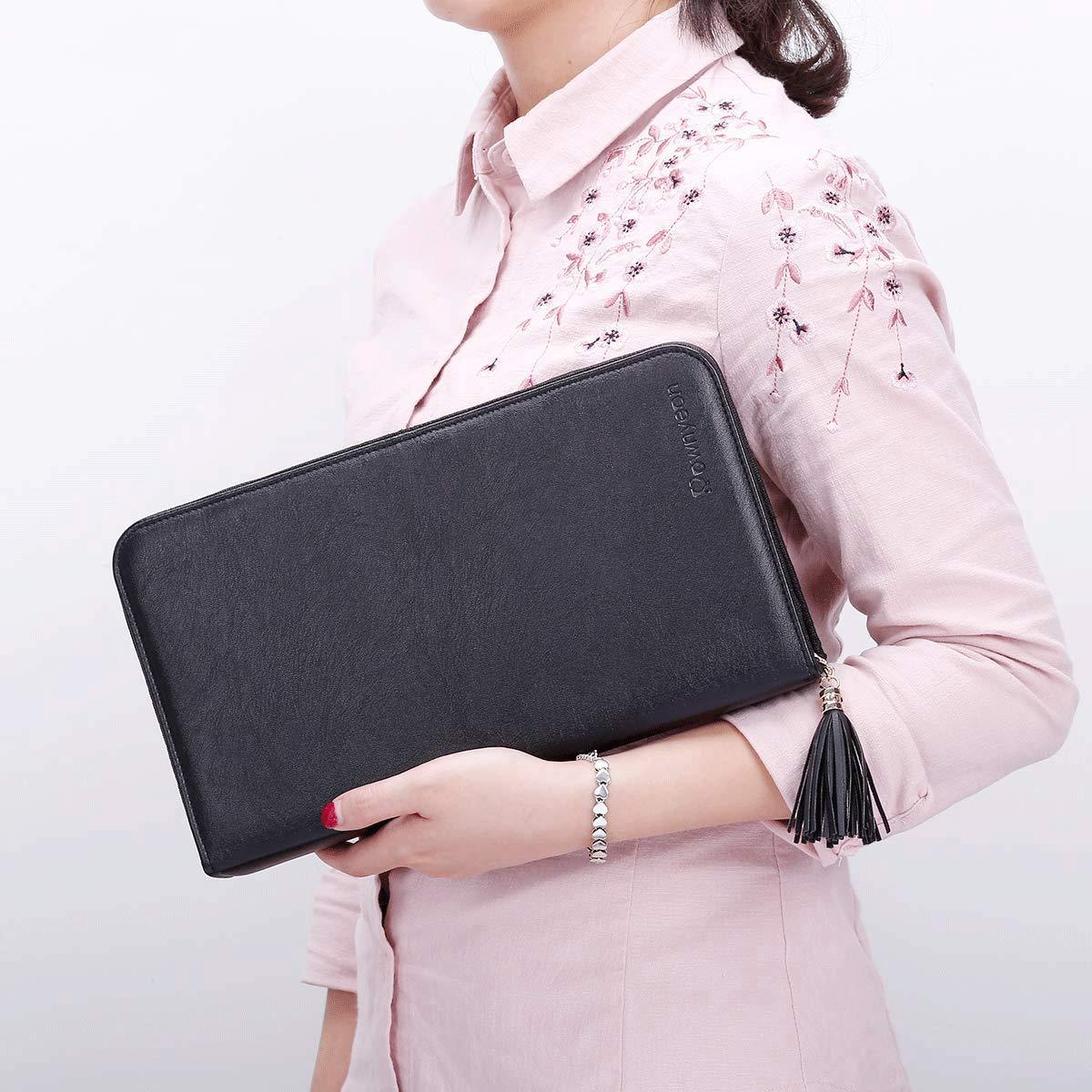 Person holding a black clutch with tassel detail against a light background