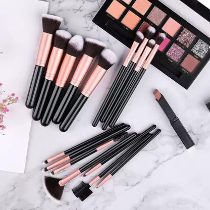 Makeup brush set with rose gold handles, eyeshadow palette, and lipstick on marble surface
