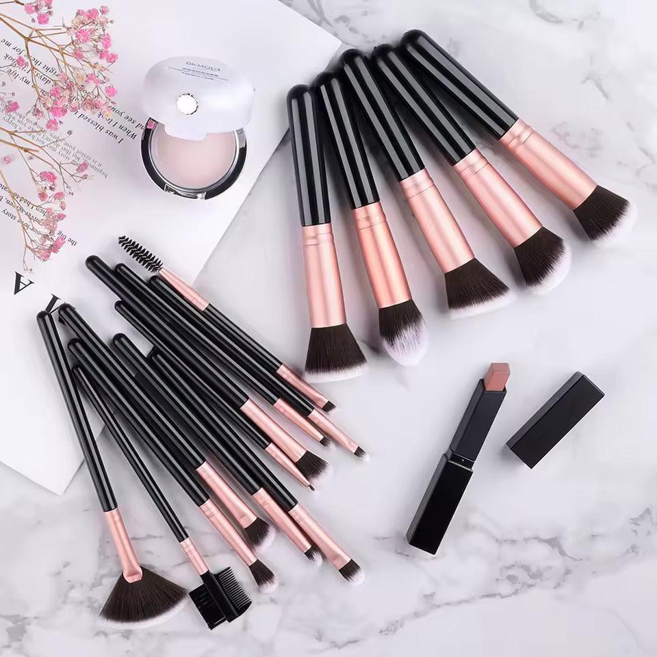 Makeup brush set, compact powder, and lipstick on marble background with flowers
