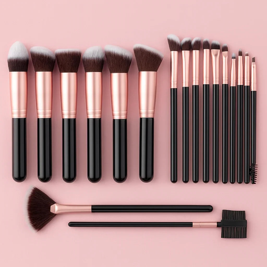 Makeup brush set with rose gold and black handles on pink background