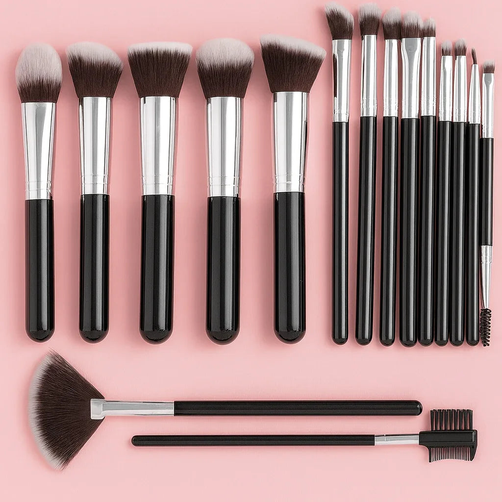 Black and silver makeup brush set arranged on a pink background