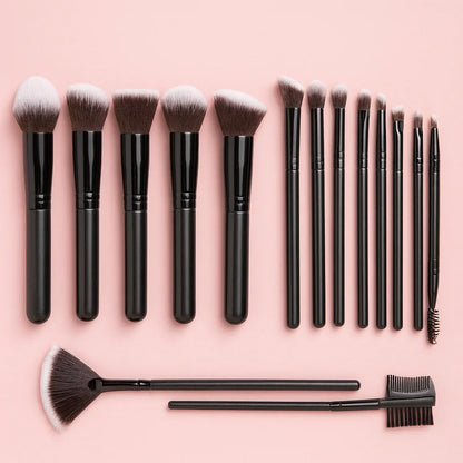 Makeup brush set with black handles on pink background, beauty tools flat lay